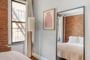 espejo en un dormitorio con cama y ventana en Hip E Village 2BR w WD nr L Train NYC-824 en Nueva York