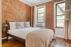 Tempat tidur dalam kamar di Hip E Village 2BR w WD nr L Train NYC-824