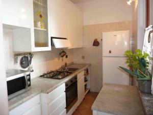 a kitchen with a stove and a white refrigerator at Casa Malandrino in Porto Valtravaglia