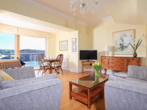 a living room with two couches and a table at 2 Channel View in Salcombe