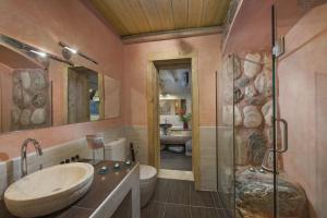 a bathroom with a sink and a shower and a toilet at Iakovakis Suites & Spa in Koropi