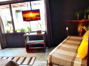 a living room with a tv and a bed and a window at Happy Paradise in Natal