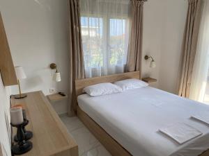 Un dormitorio con una cama grande y una ventana en sofia guesthouse en Nea Skioni