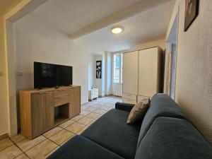 uma sala de estar com um sofá e uma televisão de ecrã plano em Charmant 2 pièces centre Sospel em Sospel