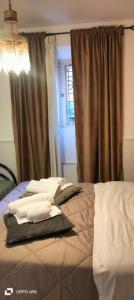 a bedroom with a bed with pillows and a window at Colosseum B in Rome