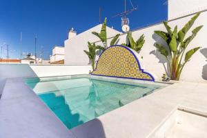 een zwembad met blauwe en gele tegels op een huis bij Feelathome San Lorenzo Apartments in Sevilla