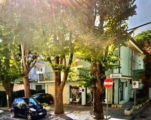 een auto geparkeerd op een straat naast bomen bij Villetta Audrey al Mare in Riccione