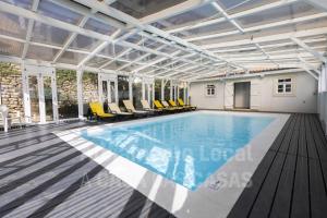 una piscina en un edificio con sillas amarillas en VIlla São Lourenço by AcasaDasCasas, en Ericeira