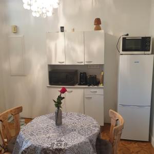 uma cozinha com uma mesa com um vaso com uma rosa em Appartement avec terrasse privative em Celles-sur-Plaine