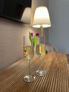 two glasses of wine and a vase of flowers on a table at Hotel Zum Fährturm in Mehring