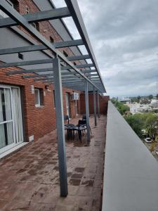 a patio with a table and chairs on a brick building at Departamento de Catagoria M&L in Villa María