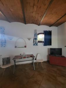 a living room with a table and a tv at La Palma appartamenti in Piombino