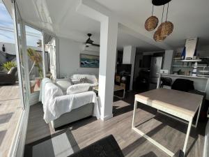uma sala de estar com um sofá e uma mesa em ATICO CLARA MIRANDO AL MAR em La Antilla