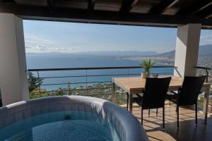 a balcony with a table and a tub at VergaView Luxury House in Kalamata