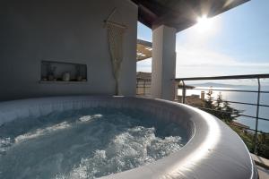 a hot tub in a room with a view of the ocean at VergaView Luxury House in Kalamata
