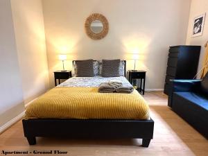 a bedroom with a bed with a yellow blanket at Charming Flats with Fast WIFI on the Famous Abbey Road in London