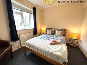 a bedroom with a bed with two lamps and a window at Charming Flats with Fast WIFI on the Famous Abbey Road in London