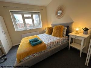 a bedroom with a bed with a yellow blanket and a window at Charming Flats with Fast WIFI on the Famous Abbey Road in London