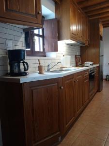 a kitchen with wooden cabinets and a sink and a stove at Monitsia Traditional House in Khalkíon +26 photos