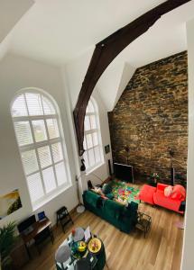 a living room with a green couch and a brick wall at Luxury 1 Bedroom Duplex with Free Parking in Plymouth