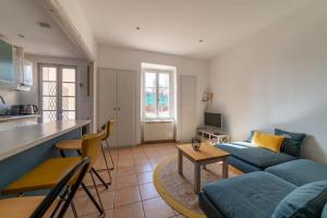 uma sala de estar com um sofá azul e uma cozinha em BEL APPARTEMENT DANS LE CENTRE D'AVIGNON em Avignon