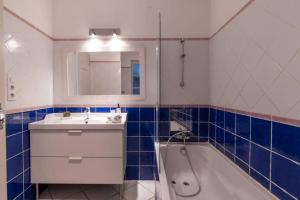 a bathroom with a sink and a tub and a mirror at BEL APPARTEMENT DANS LE CENTRE D'AVIGNON in Avignon