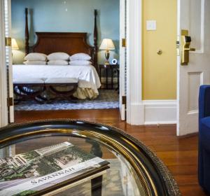 a bedroom with a bed and a table with a mirror at The Marshall House, Historic Inns of Savannah Collection in Savannah