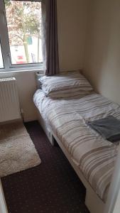 a small bed in a room with a window at Robin hood retreat 2 bedroom chalet Free parking in Nottingham