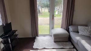 a living room with a couch and a window at Robin hood retreat 2 bedroom chalet Free parking in Nottingham
