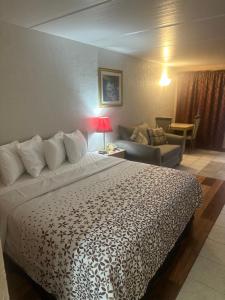 une chambre d'hôtel avec un lit et un canapé dans l'établissement THE FLORIDIAN INN, à Clearwater