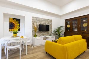 a living room with a table and a yellow couch at Mirasole House in Massa Lubrense
