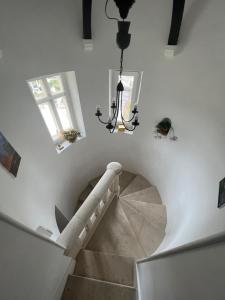 a staircase with a chandelier in a white building at LE PRIEURE DE BUFFON in Buffon