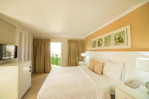 セント・ジェームスにあるMango Bay All Inclusiveのベッドとテレビが備わるホテルルームです。