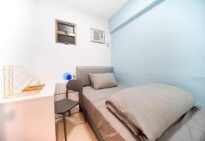 ein kleines Schlafzimmer mit einem Bett und einem Schreibtisch in der Unterkunft CoLiving Space - Hennessy Road 113 Wan Chai MTR in Hongkong