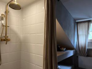 La salle de bains est pourvue d'une douche avec rideau de douche. dans l'établissement Édouard Garden Café Guest Room, à Durbuy