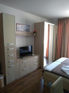 Schlafzimmer mit einem Bett und einem Flachbild-TV in der Unterkunft Studio One Diamond Beach Sarafovo in Sarafovo