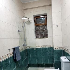 un bagno con doccia, WC e finestra di @Bazaar a Tirana