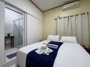 een slaapkamer met een bed met een knuffeldier erop bij Pousada Alterosa in Alter do Chao
