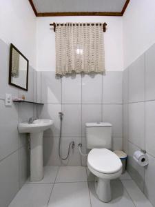 Baño blanco con aseo y lavamanos en Pousada Alterosa en Alter do Chao