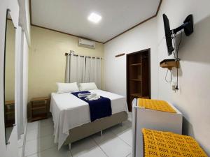 een kleine kamer met een bed en een televisie bij Pousada Alterosa in Alter do Chao