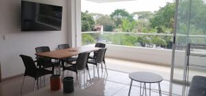a dining room with a table and chairs and a large window at Santafé Di sole in Santa Fe de Antioquia