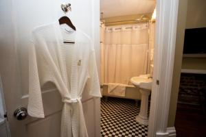 a white sweater hanging on a door in a bathroom at The Marshall House, Historic Inns of Savannah Collection in Savannah