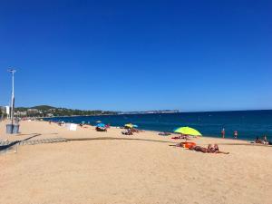 a group of people laying on a beach with umbrellas at Apartament a 2 minuts de la platja, amb AC in Platja  d'Aro