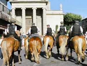 um grupo de homens cavalgando uma rua abaixo em BlueBird em Cavaillon