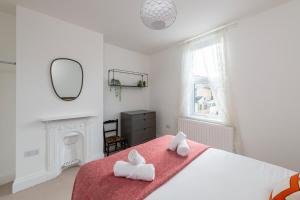 a bedroom with a large bed with two towels at Fabulous House - Only 10 minutes walk to Roman Baths in Bath