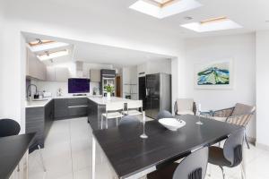 a kitchen with a large black table and chairs at Fabulous House - Only 10 minutes walk to Roman Baths in Bath