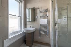 a bathroom with a sink and a shower and a mirror at Fabulous House - Only 10 minutes walk to Roman Baths in Bath +27 photos