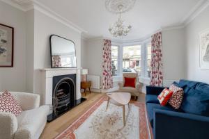 a living room with a blue couch and a fireplace at Fabulous House - Only 10 minutes walk to Roman Baths in Bath