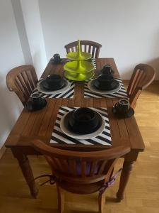 a wooden table with chairs and a green vase on it at Zentrale Appartement in Düsseldorf
