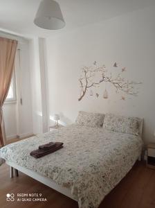 a bedroom with a bed with a tree on the wall at NICOLHOME in Rome
